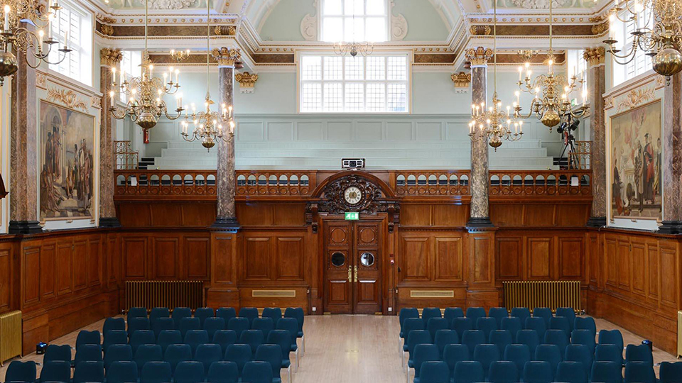 Ceremony Room at Chelsea Town hall with Wooden Walls, Large Marble columns, Chandeliers and large art painting on the walls. 