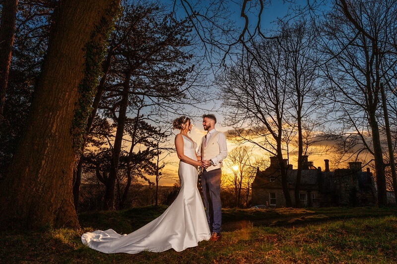 Bride and Groom holding each other in a beautiful sunset background