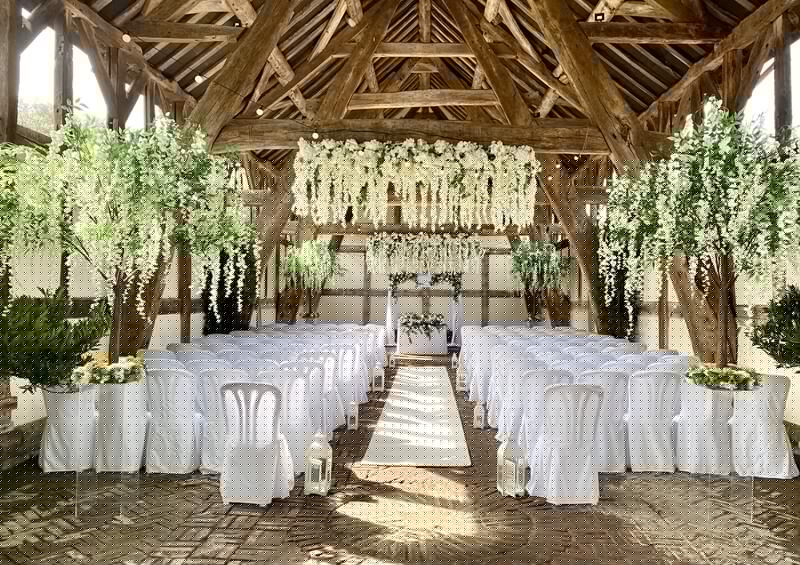 Wedding Ceremony room decorated with white flowers hanging fromt the wooden roof beams, white carpet in the middles of the aisle and chairs with white chair covers facing the front of the room