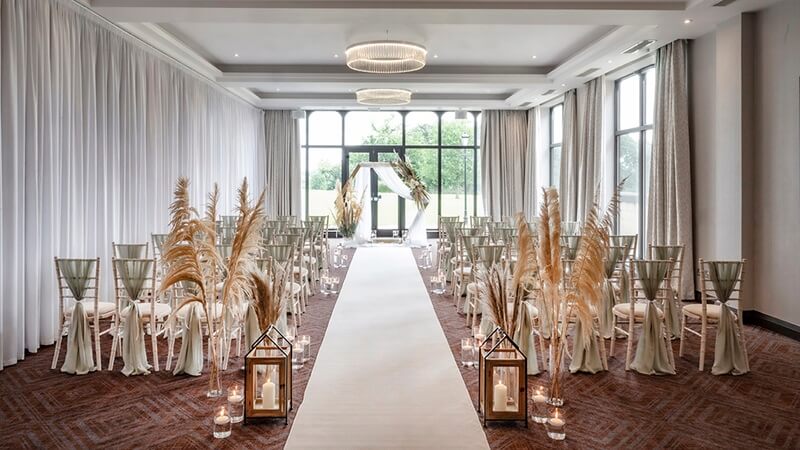 Indoor ceremony room with white carpet in the middle of the aisle