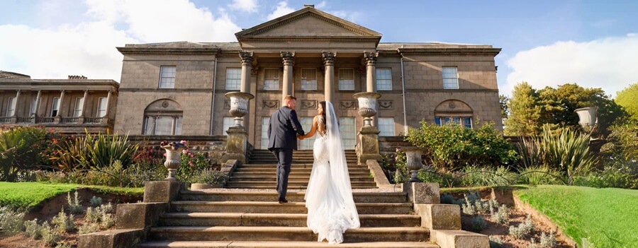 Bride and Groom walking up the stairs at the rear of Dorfold wedding venue