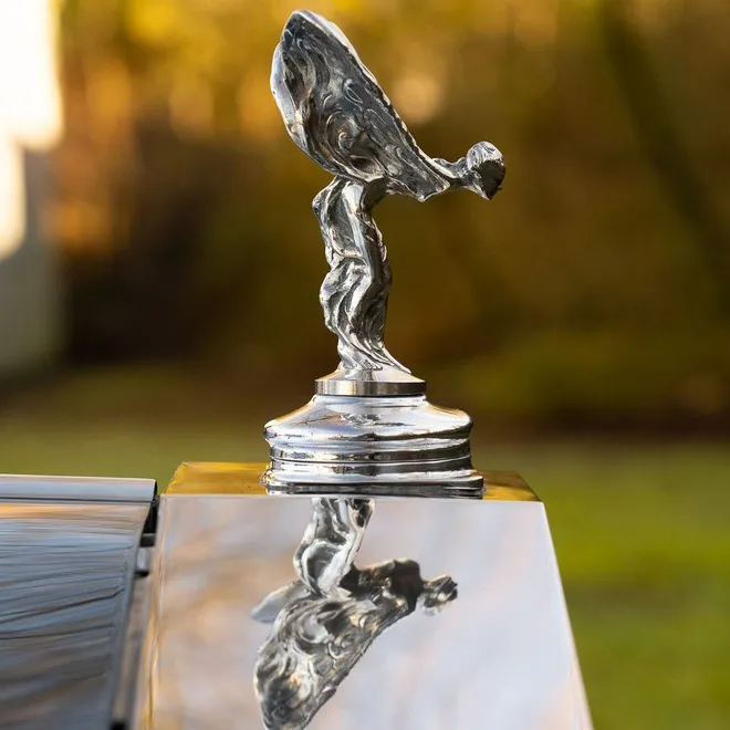 Right side of Spirit of Ecstasy siting atop of the chrome radiator with reflexion on the top of the chrome radiator