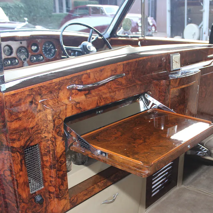 Vintage Rolls-Royce interior with wooden features, picnic tables and privacy window between chauffeur and rear passengers