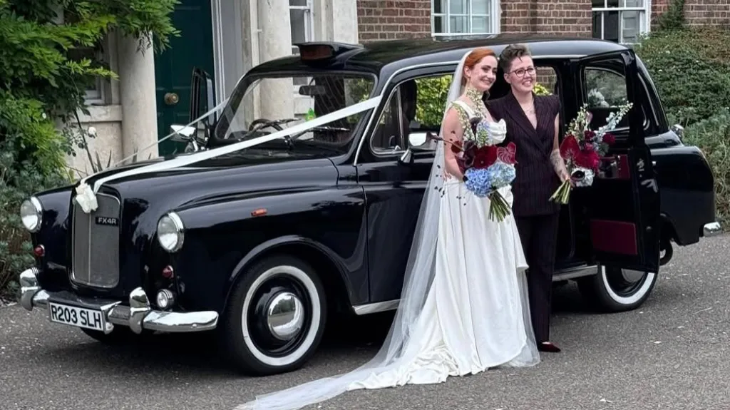 Traditional black taxi with LGBT couple used for wedding at Chelsea Town Hall