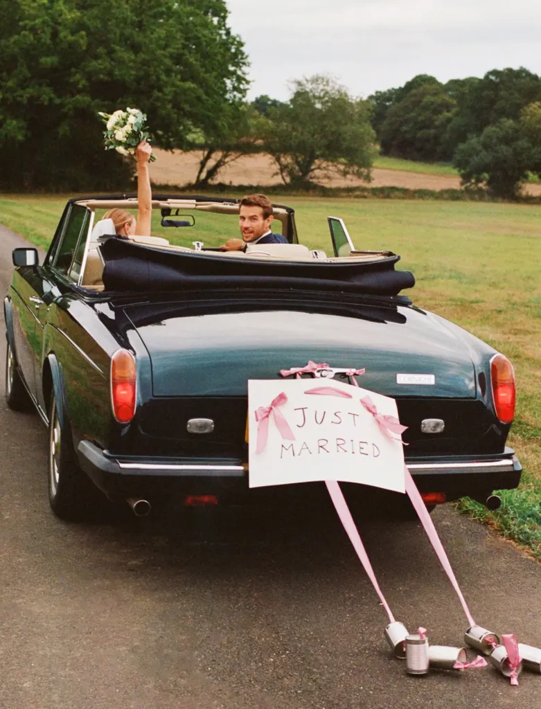 Convertible Rolls-Royce wedding car with tin cans and a Just Married sign