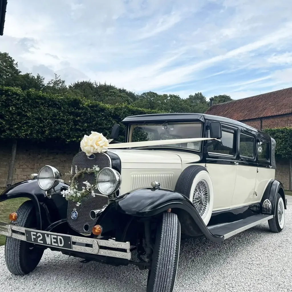 Vintage Bramwith wedding limousine decorated with ivory ribbons and a matching bow