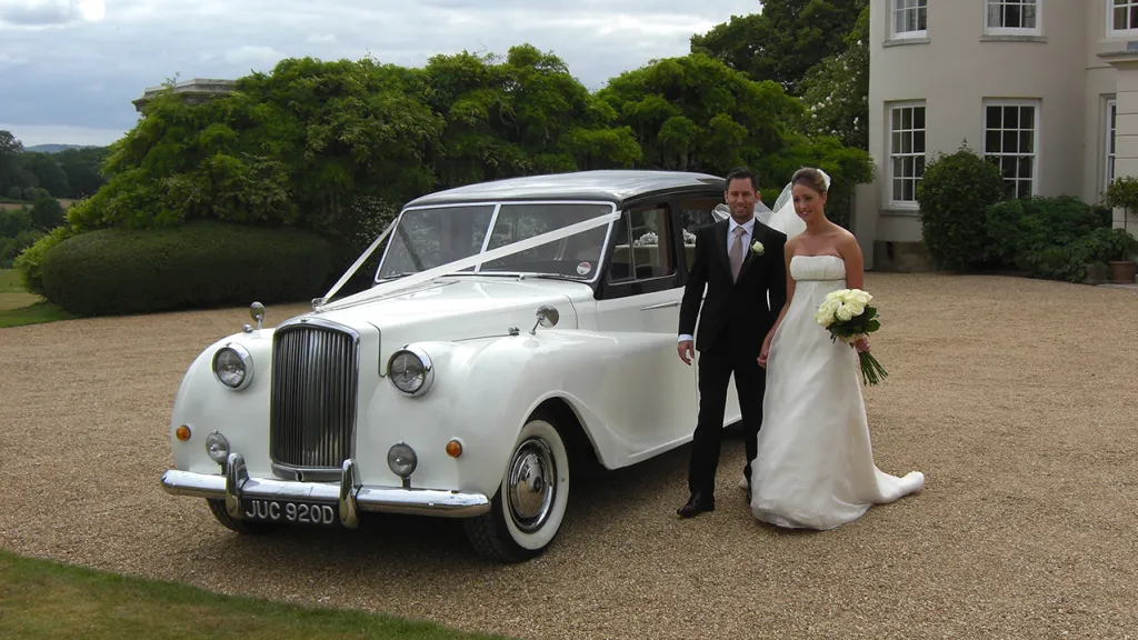 Bride and Groom stnasing next to the Austin Princess Limousine