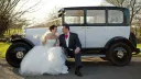 Bride and Groom seating on the running board of Citroen Deluxe Saloon