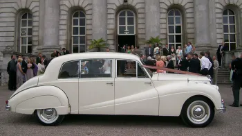 wedding guests having photos taken in front of the wedding venue in Uxbridge with the classic car