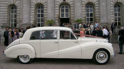 wedding guests having photos taken in front of the wedding venue in Uxbridge with the classic car