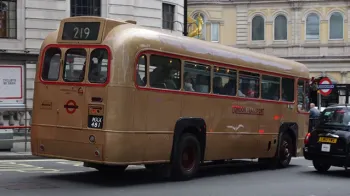 Rear view of Gold Single Decker bus in street of london