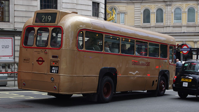 Rear view of Gold Single Decker bus in street of london