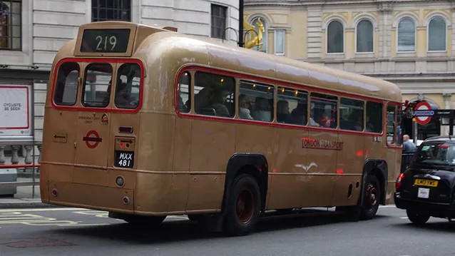 Rear view of Gold Single Decker bus in street of london