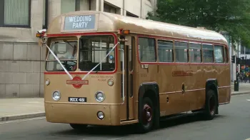 Classic Gold Single Decker bus in the street of London decorated with white ribbons