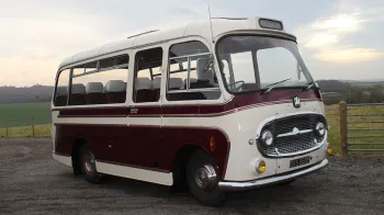 Right side view of a classic bedford bus in Cream and Burgundy