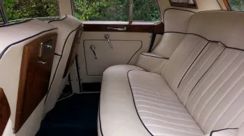 Rolls-Royce Silver Cloud rear interior with crema leather interior, blue pipping and wooden table