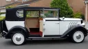 Right side view of vintage style regent with rear passenger door open showing a cream leather interior and deep red carpet
