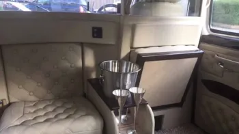Casual seats inside rear cabin of classic taxi in cream leather with Champagne basket holder