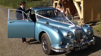 Bride and Groom entering the classic Daimler 250 V8 car