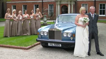 Six Bridesmaids with matching Ivory dressed stands in the background and Bride and Groom at the front of the Rolls-Royce Silver Shadow II in Blue and Silver