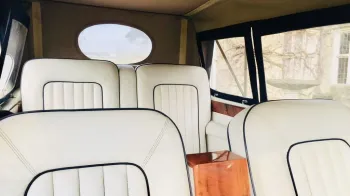 Beauford interior white leather seat with soft top hood closed taken from the chauffeur's seat looking towards the rear of the vehicle