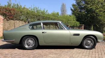 Right view of classic Aston Martin DB6 in pale metallic green without ribbons. Chrome spokes wheels