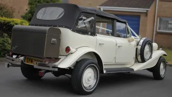 Rear view of ivort vintage BEauford showing black picnic trunk at the rear of the vehicle