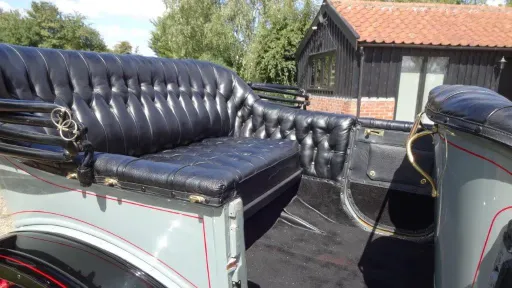 Oakland Model rear interior photo with rear door open showing large leg room. Seats are in Black Leather and Black Carpet