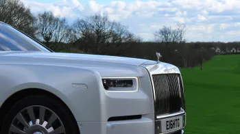close-up view of white Rolls-Royce Phantom 8 front chrome grill with spirit of ecstasy a top.
