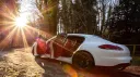 Rear side view of Porsche Panamera with both rear and passenger doors open showing its burdungy interior