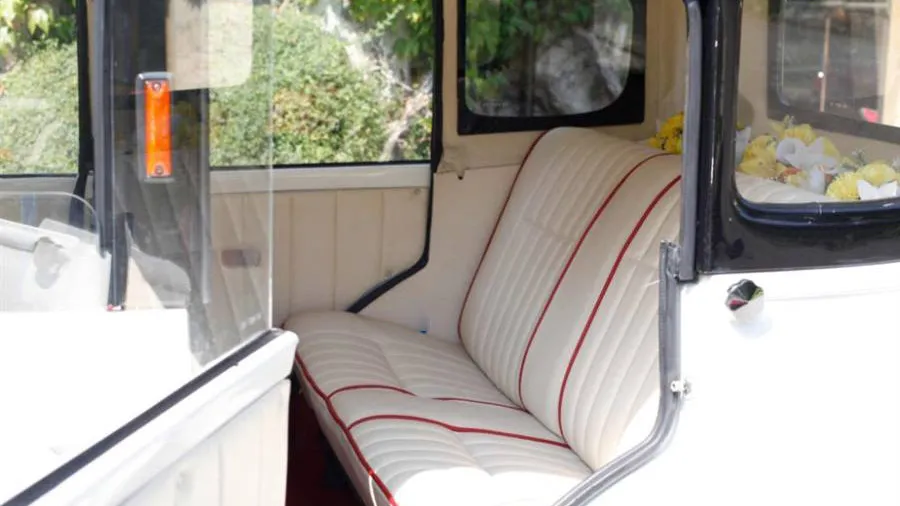 Rear passenger interior photo with cream leather seats and burgundy pipping