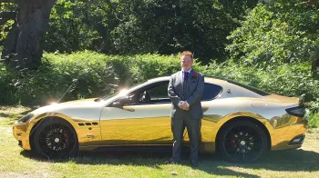 Maserati GranTurismo 'S' with groom standing in front of the vehicle in a green grass field