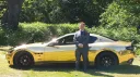 Maserati GranTurismo 'S' with groom standing in front of the vehicle in a green grass field