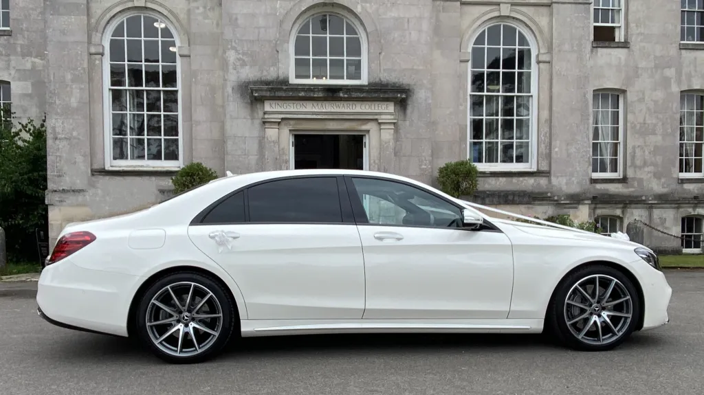 Right side view of White Mercedes decorated with white ribbons and large chrome alloy wheels