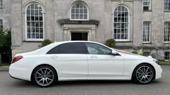 Right side view of White Mercedes decorated with white ribbons and large chrome alloy wheels