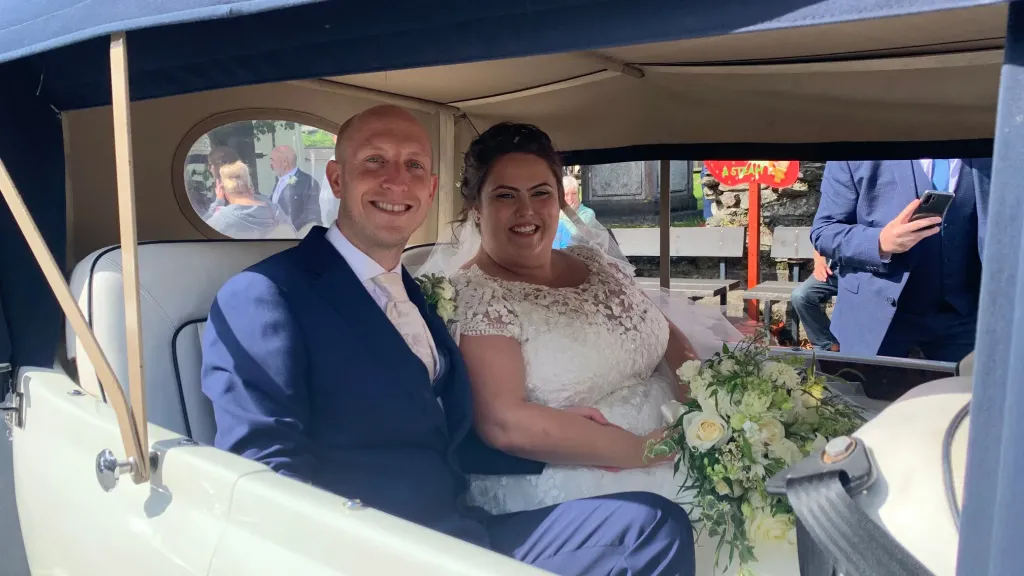 Bride and Groom seating inside vintage Beauford