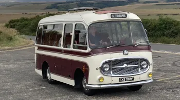 Front rioght view of a classic single decker bedford Bus in cream with Burgundy on the side