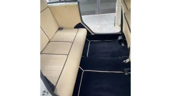Cream leather interior rear bench seat inside Beauford Convertible with blue carpet
