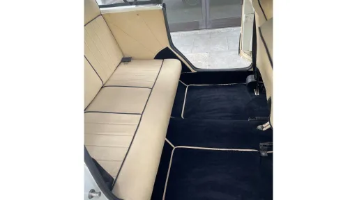 Cream leather interior rear bench seat inside Beauford Convertible with blue carpet