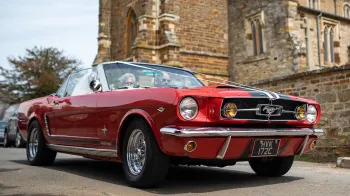 Ford Mustang Convertible with white ribbons in front of a church
