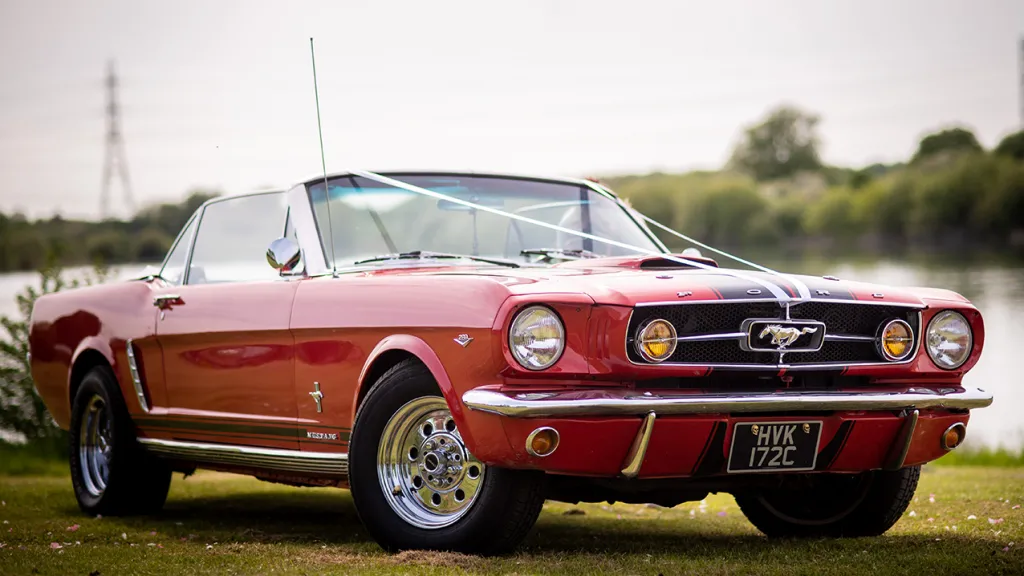 Red Ford Mustang for Hire decorated with white ribbons