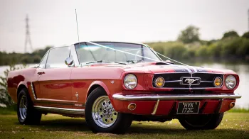 Red Ford Mustang for Hire decorated with white ribbons