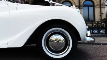 close up view of chrome wheel cap with thin white wall tires on an Austin Princess,