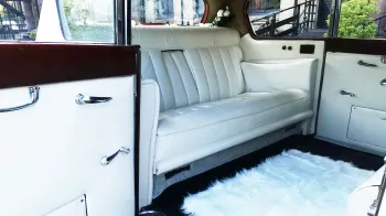 rear interior cabin photo showing white leather seats and a white rug on the floor