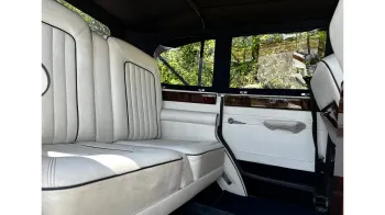 Rear interior seating area showing white leather seats and large legroom