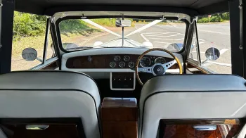 Beauford interior shot taken frot the rear passenger seat looking towards the front with rear wooden picnic table, wooden dashboard