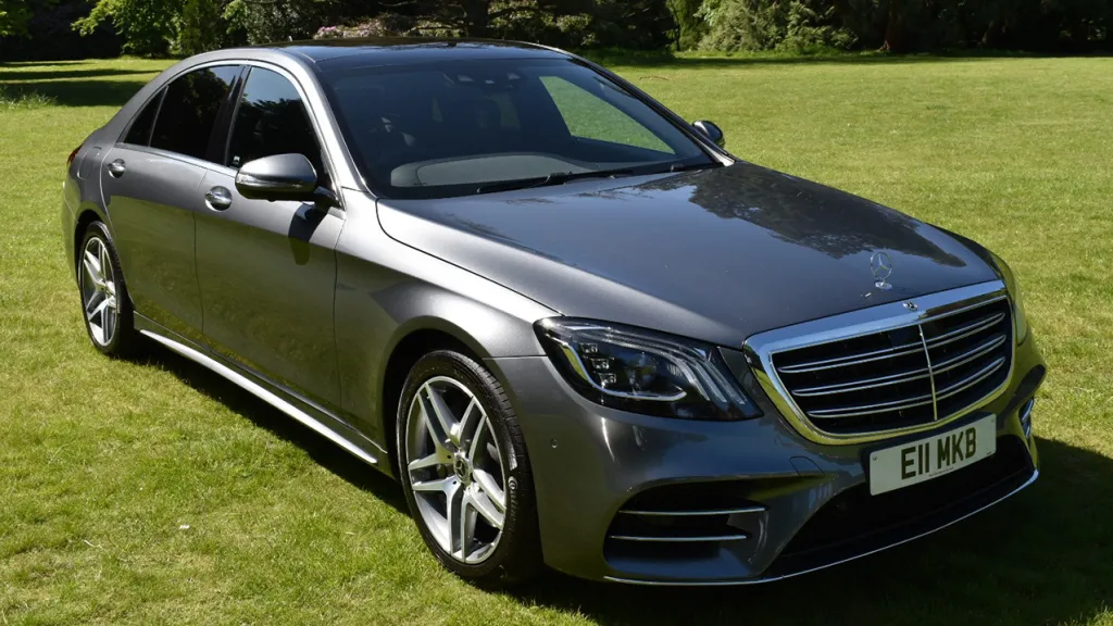 Grey Mercedes front side view parked in a park with green grass