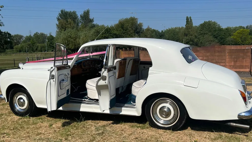 Side view of Classic Rolls-royce with both doors open showing interior in cream leather