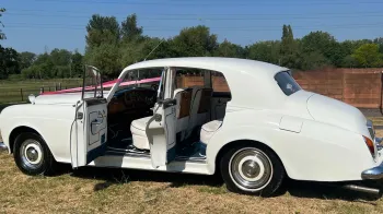 Side view of Classic Rolls-royce with both doors open showing interior in cream leather