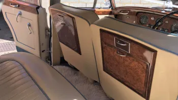Rear seat of the classic rolls-royce with cream leather interior and blue pipping